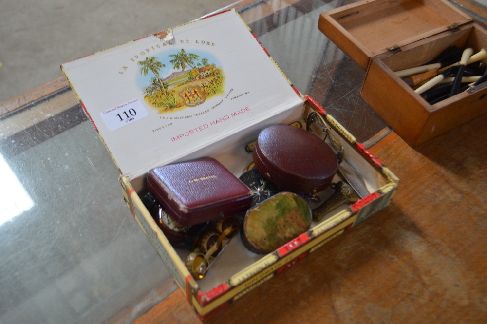 A cigar box containing a boxed set of dress studs,