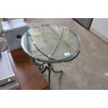 A circular metal framed and glass topped table rai