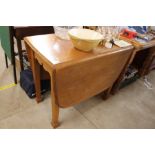 A light oak drop leaf dining table