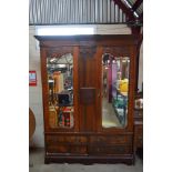 An Edwardian carved mahogany mirrored door wardrob