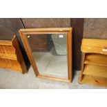 A pine framed and bevelled edge wall mirror