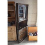 An oak and glazed upright corner cabinet