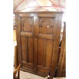 A large oak two door wardrobe, made by Lock of Lon