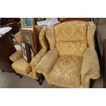 Two upholstered wing back armchairs