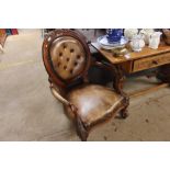 A carved walnut button back upholstered armchair