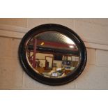 An oval framed and bevel edged wall mirror