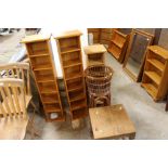 Three narrow shelf units; a wicker plant stand and