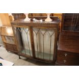 A mahogany bow front display cabinet, raised on ba