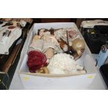 A box of various dressed dolls