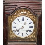 A French provincial carved walnut long case clock, having brass and enamel dial supporting an