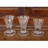 Three Masonic glasses, of tapering form, etched with symbols and raised on circular spread feet,