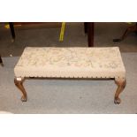 An 18th Century style mahogany long stool, with needlepoint upholstery, raised on cabriole