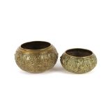 Two heavily carved 19th Century South Asian Buddhist brass bowls, the largest 15cm high