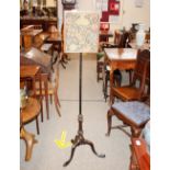 An antique mahogany pole screen, with embroidered banner raised on turned and fluted column and