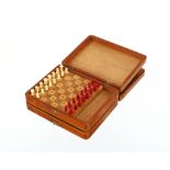 A white metal box, with playing cards and a wooden miniature travelling chess set
