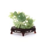 A jade fruit carving, on hardwood base, the carving 15cm high x 20cm long