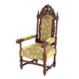 A Victorian carved oak elbow chair, having leaf decoration and barleytwist columns