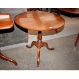 A 19th Century circular oak snap top occasional table, raised on a turned column and tripod base,