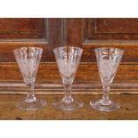 Three Masonic etched wine glasses, having shield motifs, raised on circular spread bases, some