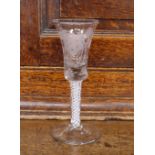 An Antique drinking glass, the bell shaped bowl etched with flowers and butterflies, supported on