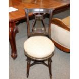 A 19th Century music chair, having lyre shaped back splat above a circular upholstered stuff over