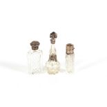 Three glass silver and white metal mounted scent bottles