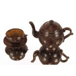 A carved coconut teapot, having floral decoration and a matching cup and saucer (3)