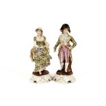 A pair of 19th Century German porcelain figures, of a lady and gallant, wearing brightly coloured