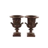 A pair of classical style bronze campana shaped urns, decorated with semi naked figures and foliage,