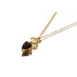 A 14 carat gold mounted citrine and smokey topaz pendant, hung to a 14 carat gold fine link chain,