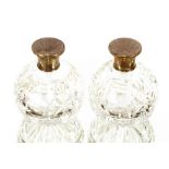 A pair of Art Deco cut glass scent bottles, the silver mounts with engine turned decoration