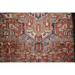 An Eastern carpet of Caucasian design, decorated stylised medallions and geometric borders, on