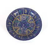 A 19th century Iznik style bowl, predominately in blue heightened with yellow and green within a