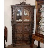 An antique continental corner cabinet, profusely decorated masks, lozenges and foliate roundels, the
