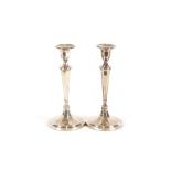 A pair of modern silver candlesticks, having detachable sconces raised on tapering column and