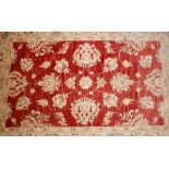 An Eastern wool and silk rug, having floral decoration on a red ground, 146cm x 98cm