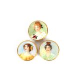 Three large decorative porcelain buttons, each depicting head and shoulders study of young beauties