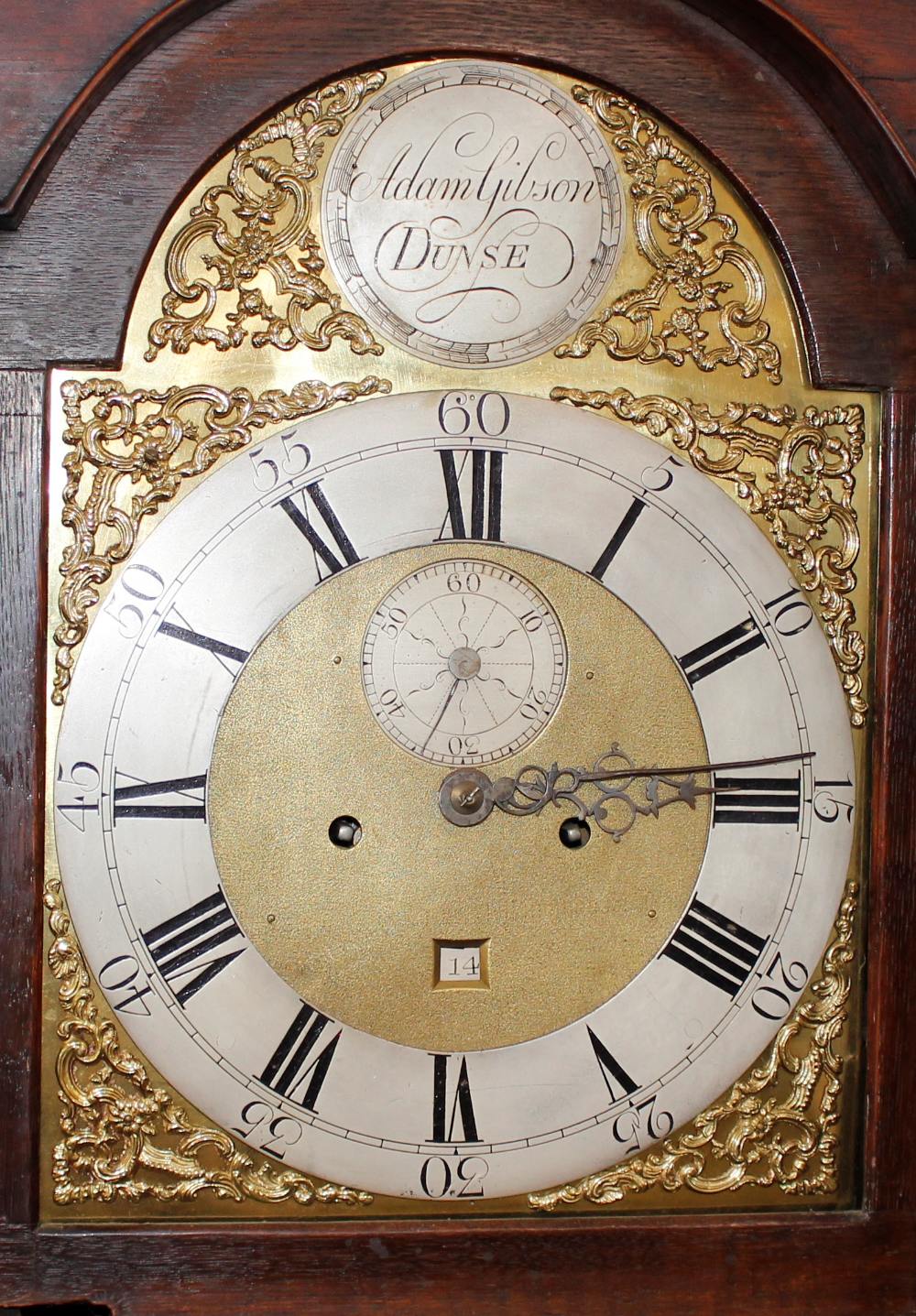 A Georgian oak long case clock, the arched hood enclosing brass spandrel dial with steel chapter