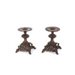 A pair of Coalbrookdale style pricket sticks, having pierced decoration and raised on figural