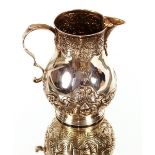 An Edwardian silver baluster cream jug, having bird beak spout with raised floral embossed