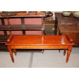 A mahogany Regency style window seat, having turned scrolled ends, raised on tapering turned
