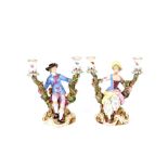 A pair of 19th Century Meissen porcelain figural candlesticks, depicting maid and youth seated on