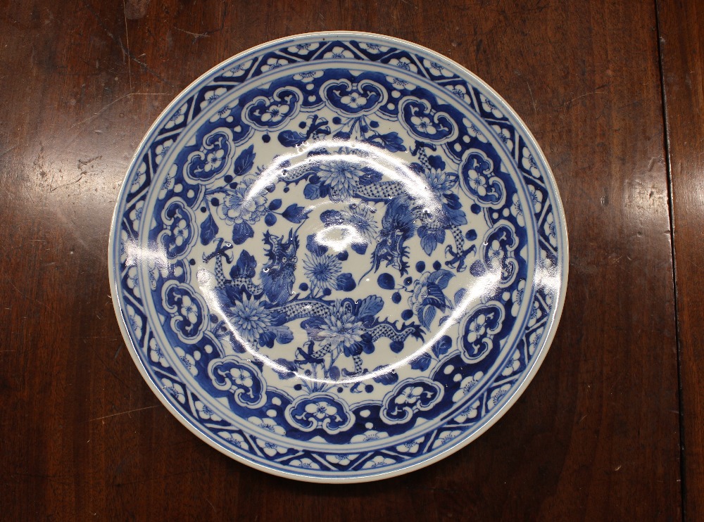 A Chinese blue and white shallow dish, the central field decorated with flowers, 20.5cm dia. six