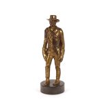An early 20th Century gilt bronzed figure, possibly of the cowboy Wyatt Earp with hat, pistol,