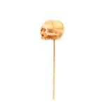 A gold stick pin, with bone skull terminal