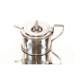 A silver drum shaped mustard pot, with beaded border and crest, London 1802, having associated spoon