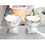 A pair of garden urns, having leaf decoration on square bases, 46cm dia. x 42cm high