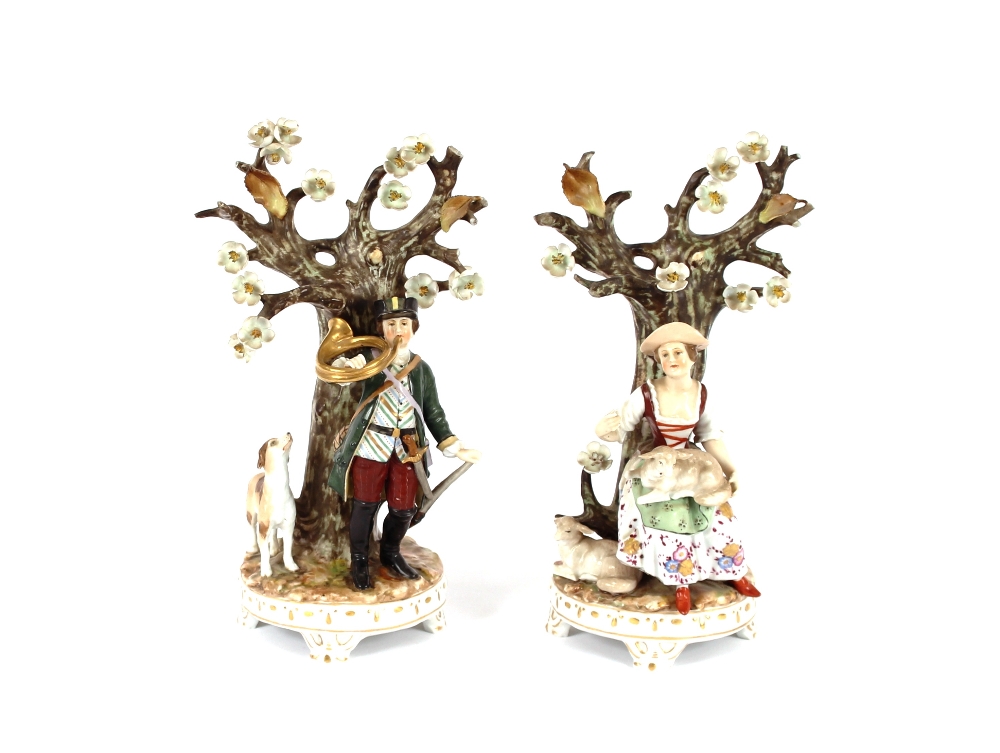 A pair of Continental porcelain figures, depicting a shepherdess and a huntsman standing in front of