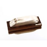 A white metal stylised model of a racing car, on wooden base, bears signature