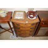 A walnut veneered bow front chest fitted four draw